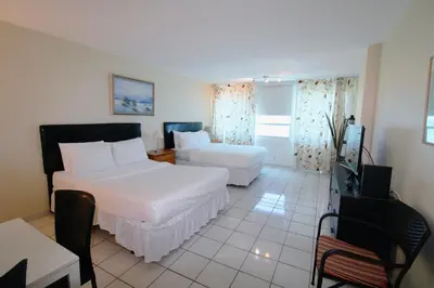 a hotel room with two beds and a television at Castle 1733 Ocean view studio with direct beach access, pool, tennis & free parking in Miami Beach