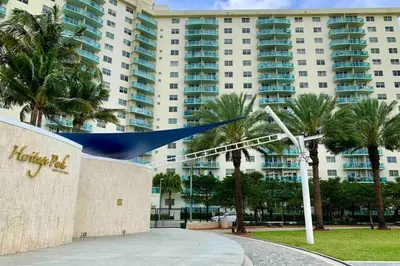 a large building with palm trees in front of it at Beautiful Apartment Steps Away from the Beach in Miami Beach