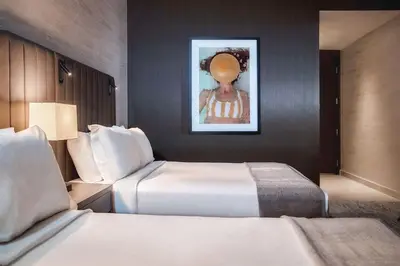 a hotel room with two beds and a painting on the wall at THesis Hotel Miami Coral Gables, Curio Collection by Hilton in Miami