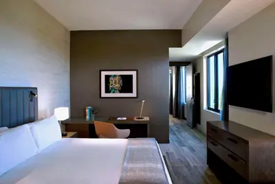 a hotel room with a bed and a desk and a tv at THesis Hotel Miami Coral Gables, Curio Collection by Hilton in Miami