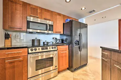 a kitchen with stainless steel appliances and wooden cabinets at Waterfront High-Rise Condo - Miami Beach 5 Mi in Miami