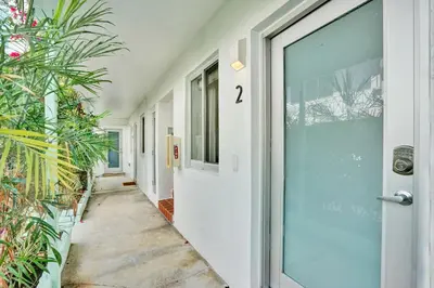 an empty hallway with a door and plants at Lincoln Villa Suites in Miami Beach
