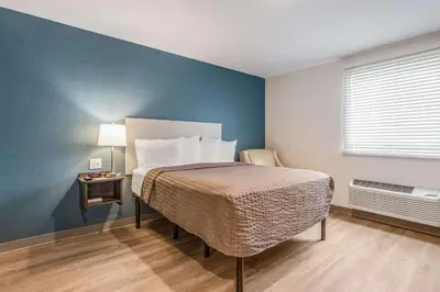a bedroom with a bed and a blue wall at WoodSpring Suites Doral Miami Airport in Miami