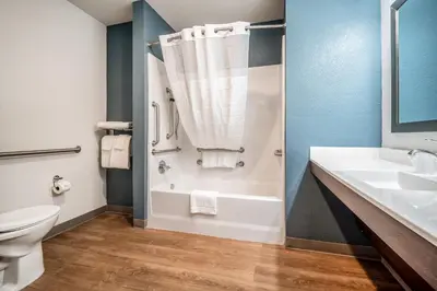 a bathroom with a tub and a sink and a toilet at WoodSpring Suites Doral Miami Airport in Miami