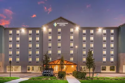 an exterior view of a hotel at night at WoodSpring Suites Doral Miami Airport in Miami