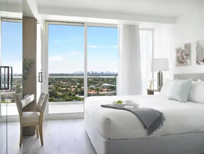 a white bedroom with a large bed and a large window at Grand Beach Hotel Surfside in Miami Beach