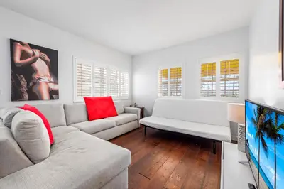 a living room with a couch and a tv at South Beach Suites in Ocean Drive in Miami Beach