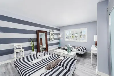 two beds in a room with blue and white stripes at South Beach Suites in Ocean Drive in Miami Beach
