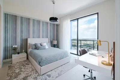 a bedroom with a bed and a desk and a window at Provident Grand Luxury Short-Term Residences in Miami