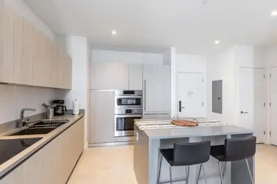 a kitchen with white cabinets and a counter with bar stools at Penthouse 2 Terraces Ocean Views Beach Access in Hollywood
