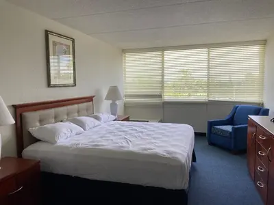 a bedroom with a bed and a blue chair at Miami Gardens Inn & Suites in Miami