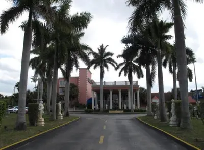 a street with palm trees in front of a building at Miami Gardens Inn & Suites in Miami