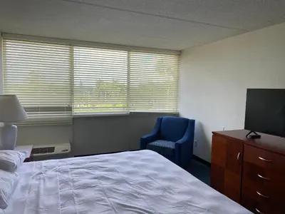 a bedroom with a bed and a chair and a television at Miami Gardens Inn & Suites in Miami