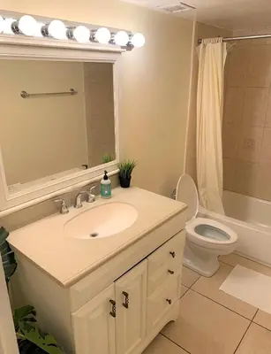 a bathroom with a sink and a toilet and a mirror at Bposhtels Hollywood Florida in Hollywood