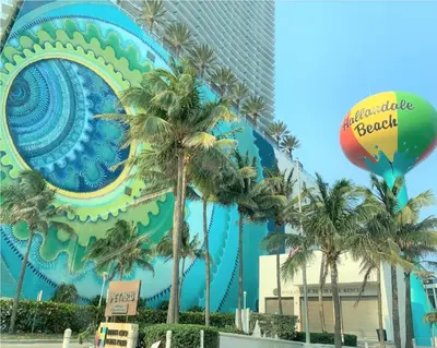 a building with palm trees in front of it at Bposhtels Hollywood Florida in Hollywood