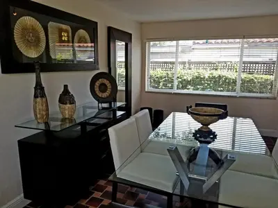 a dining room with a glass table and chairs at FAMILY Guayabita's House in Miami