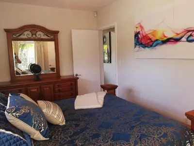 a bedroom with a blue bed and a mirror at FAMILY Guayabita's House in Miami