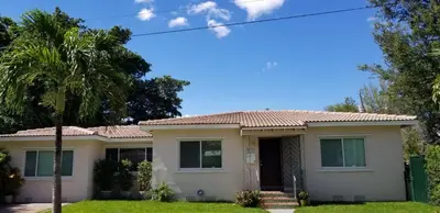 a house with a palm tree in front of it at FAMILY Guayabita's House in Miami