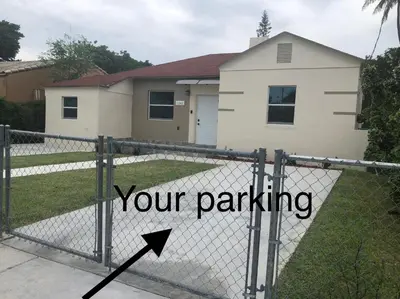 a sign on a fence that says your parking at Your House in Miami in Miami