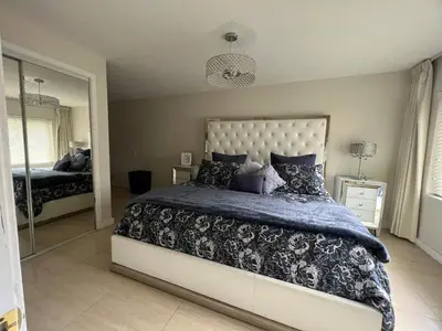 a bedroom with a large bed and a mirror at LUXURY Guayabita's House in Miami