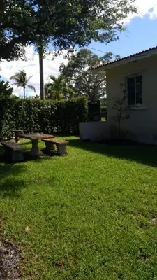 a backyard with a picnic table in the grass at LUXURY Guayabita's House in Miami