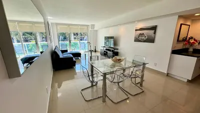 a dining room and living room with a glass table at Sunny Isles, beach life! Parking included in Miami Beach
