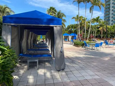 a row of blue chairs under a blue tent at Sunny Isles, beach life! Parking included in Miami Beach