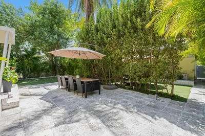a table and chairs with an umbrella on a patio at villa venezia bb in Miami Beach