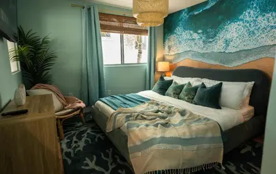 a bedroom with a bed with a painting on the wall at Fountain condo 2 story Pool BBQ Balcony in Miami Beach