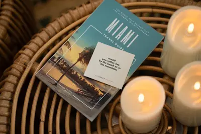 a book sitting on top of a wicker basket with candles at Fountain condo 2 story Pool BBQ Balcony in Miami Beach
