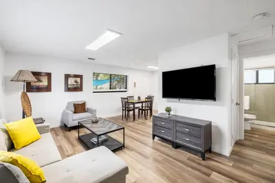 a living room with a couch and a tv on a wall at Harbourside Flats in Fort Lauderdale
