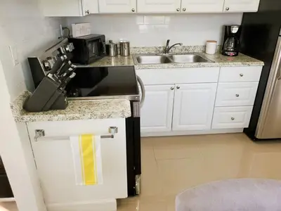 a kitchen with a sink and a stove top oven at Sophisticated Dania Beach Suites Near the Beach in Dania Beach