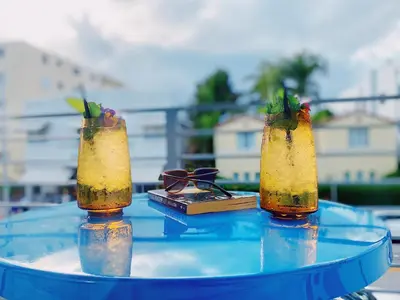 two cocktails on a table with a book on it at Rock Apartments by Lowkl in Miami Beach