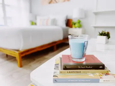 a glass of water sitting on top of books on a table at Rock Apartments by Lowkl in Miami Beach