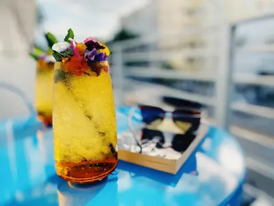 a drink sitting on a table next to a box at Rock Apartments by Lowkl in Miami Beach