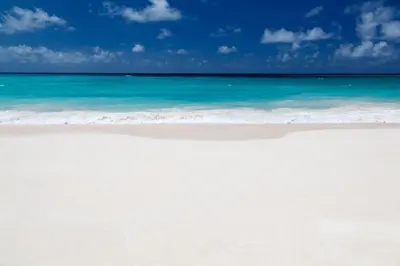 a white beach with the ocean and blue sky at Sunny Isles Ocean Reserve Condo Apartments - 1BR #812 in Miami Beach