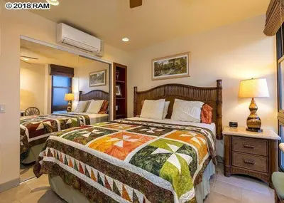 a bedroom with two beds and a mirror at South Maui Condos in Miami Beach