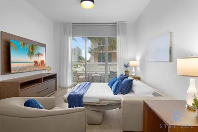 a bedroom with a bed and a couch and a television at Beachfront Resort - Hot Tub & Pool- Near Beach in Hollywood