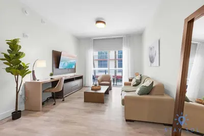 a living room with a couch and a desk at Tropical Oasis - Rooftop Pool- Near Beach - Gym in Hollywood