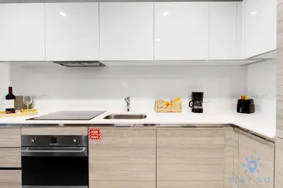 a kitchen with white cabinets and a black dishwasher at Tropical Oasis - Rooftop Pool- Near Beach - Gym in Hollywood