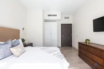 a bedroom with a white bed and a flat screen tv at Most Liked Home - Rooftop Pool - Hollywood Beach - Gym in Hollywood