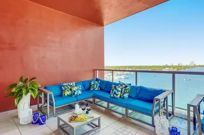 a blue couch on a balcony with a view of the water at Most Liked Home - Rooftop Pool - Hollywood Beach - Gym in Hollywood