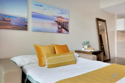 a bedroom with a bed with yellow pillows and a painting on the wall at Condo Resort - Best Stay - Balcony - Rooftop pool - Gym in Hollywood