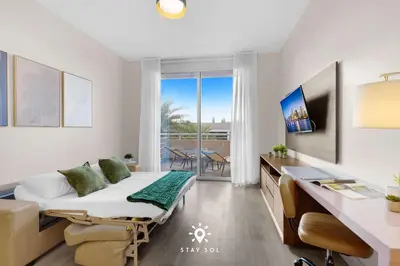 a hospital room with a bed and a desk and a table and chairs at Modern Resort - Terrace - Up To 6 - Near Beach in Hollywood