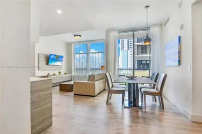 a dining room and living room with a table and chairs at Near Beach - Rooftop Pool - Hot Tub - Broad-walk in Hollywood