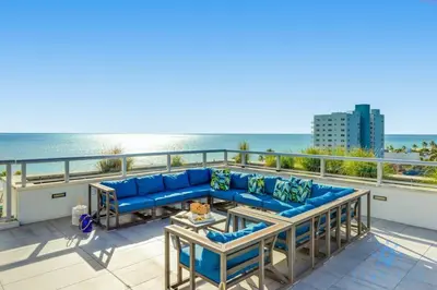 a blue couch on a balcony with the ocean at Ocean View - Balcony - Hollywood Beach Broad-walk in Hollywood