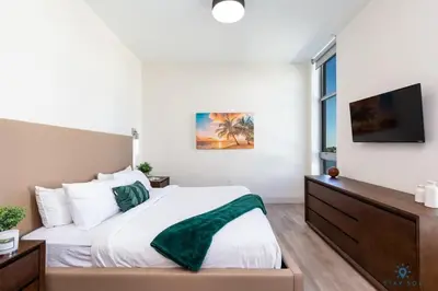 a bedroom with a large bed and a flat screen tv at Rooftop Pool- Gym - Hollywood Beach Broad - walk in Hollywood