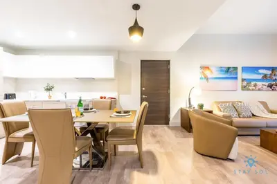 a dining room and living room with a table and chairs at NEW LUXURY Beachfront Condo Resort in Hollywood