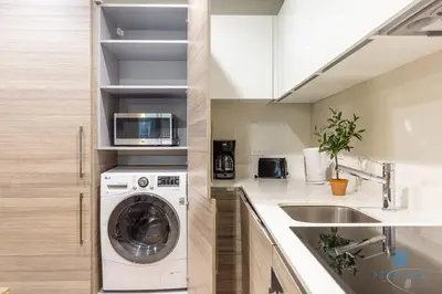 a kitchen with a washing machine and a sink at NEW LUXURY Beachfront Condo Resort in Hollywood