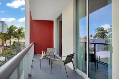 a balcony with a table and chairs on a building at Best Stay - Rooftop Pool & Hot Tub - Hollywood Beach in Hollywood